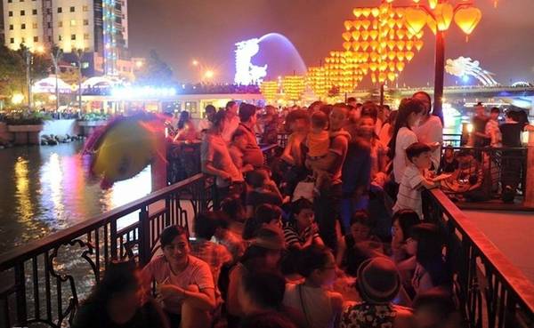 Người dân ngồi kín cầu tàu trên đường Trần Hưng Đạo lúc 19h45. Ảnh: Mạnh Thắng